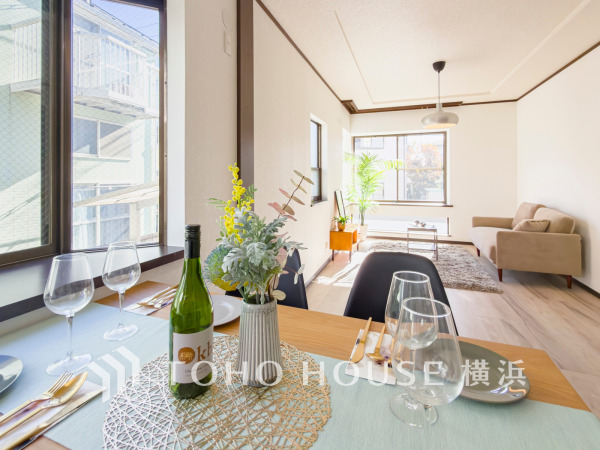 陽光が差し込む明るいリビングダイニング。落ち着いた色合いの家具が調和し、ゆったりとくつろげる空間です。