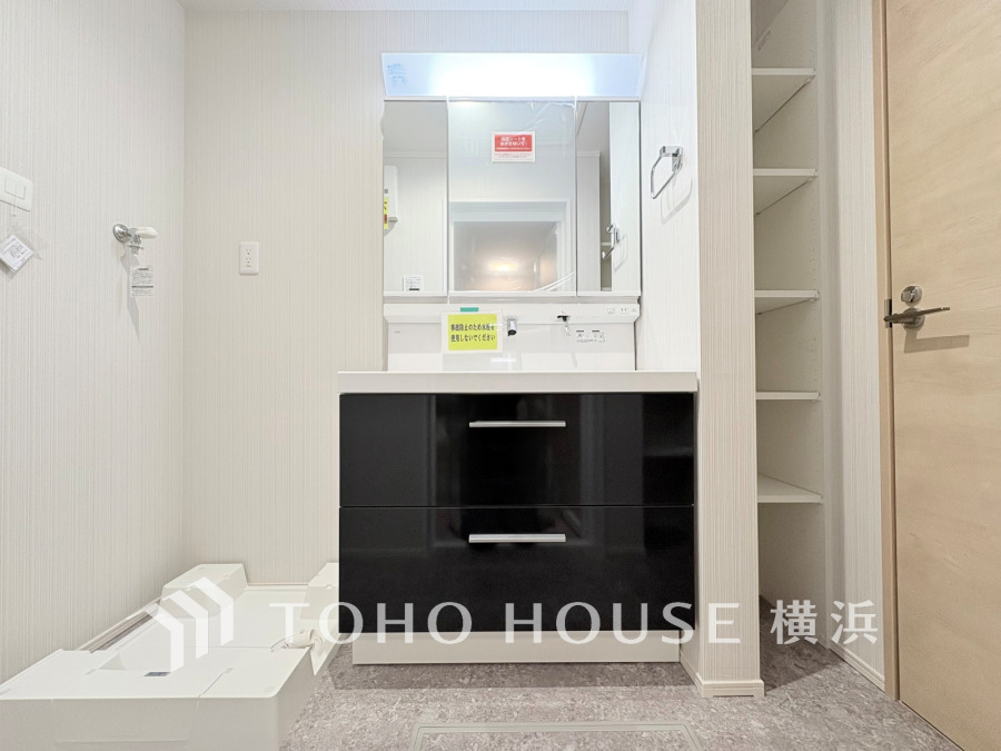 収納スペース充実の洗面台と洗濯機置き場。清潔感ある白を基調とした使い勝手の良い洗面所です。