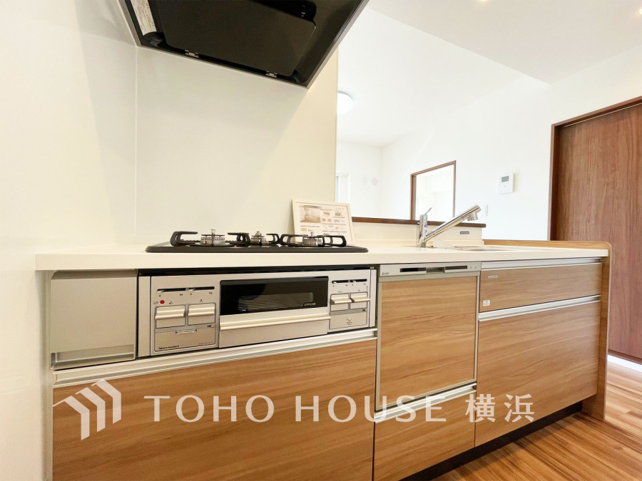 木目調の温かみあるキッチンは、使いやすさと清潔感を兼ね備えた機能的な設計です。