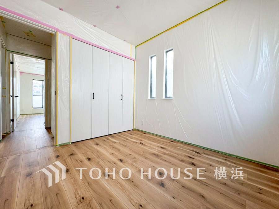 【2025年11月撮影】温かみのある木目床と白い扉が調和した明るい洋室。収納力も備え、快適な住空間を実現します。