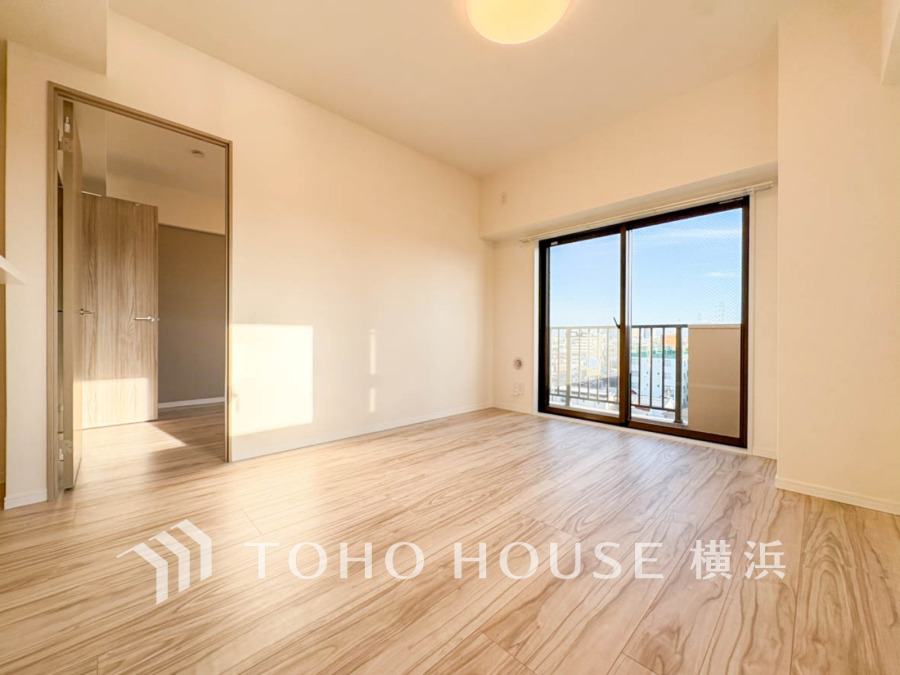 明るい陽光が差し込む、広々としたリビング。大きな窓からは開放的な景色が楽しめます。