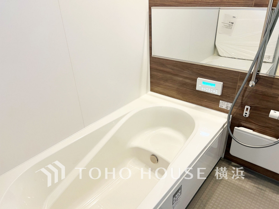 木目調パネルが温かみを演出するバスルーム。快適な入浴をサポートする設備も充実しています。