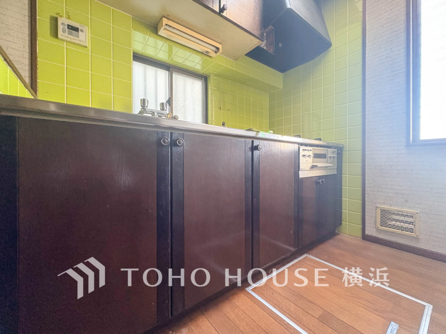 レトロなグリーンタイルが特徴のキッチン。収納豊富で使いやすいシンプル設計です。自然光が差し込み明るい空間。