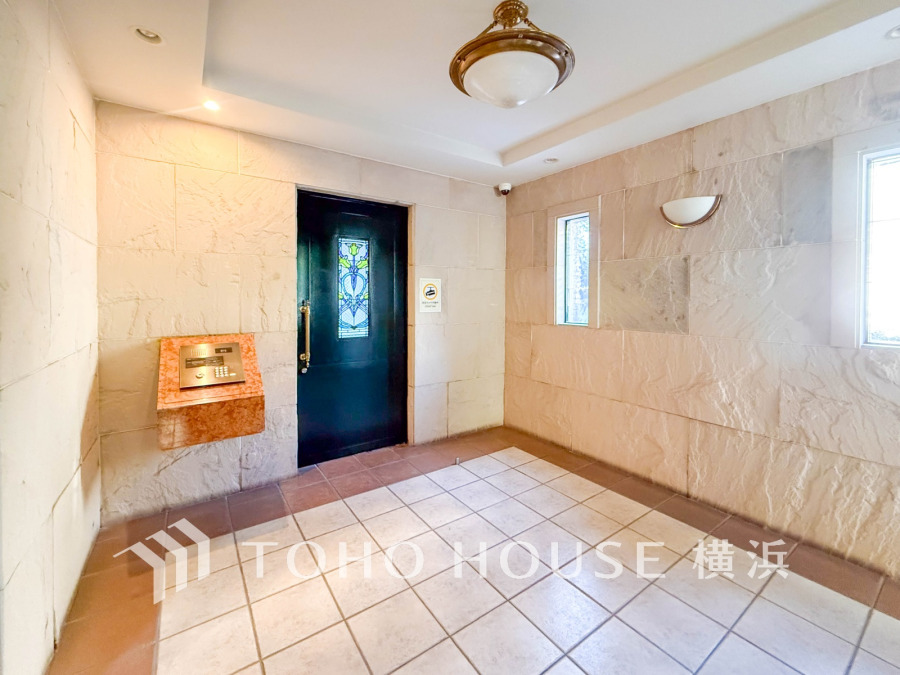 温かみのある石壁とステンドグラス扉が印象的なエントランスホール。安心のオートロック完備です。