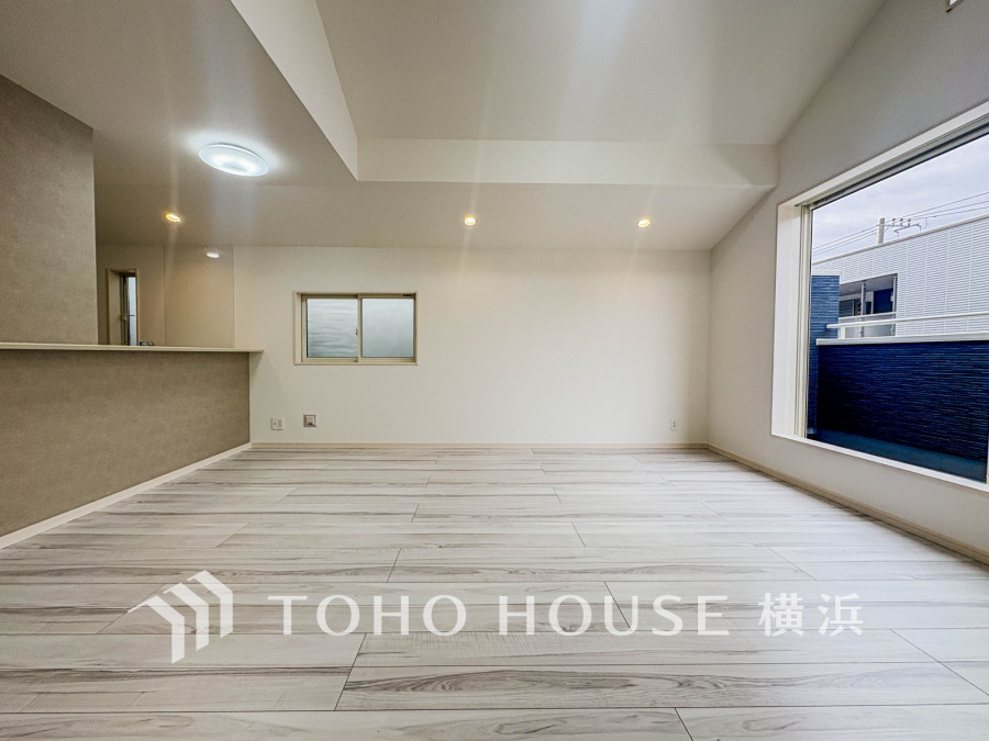 大きな窓から自然光が差し込む、開放感あふれる明るいリビング空間。シンプルで使いやすい設計です。