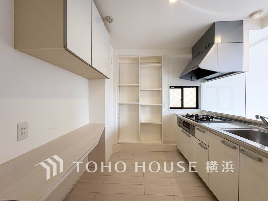 収納棚を背面に設置した統一感のあるキッチンスペースは美しく、機能性も良好です。
