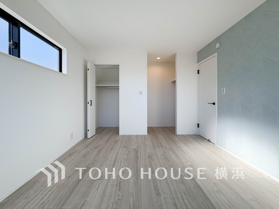 明るい陽光が差し込む居室は、水色のアクセントクロスが爽やかな印象を与えます。二つのクローゼットで収納力も充実しており、お子様の成長に合わせて様々に活用できる空間です。