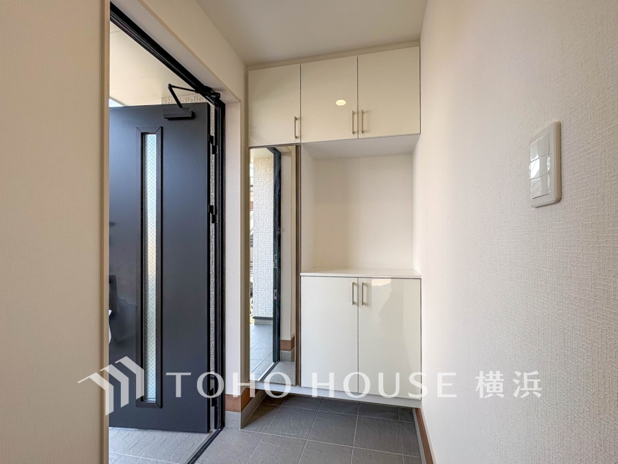 清潔感あふれる玄関スペース。収納力の高いシューズボックスと姿見鏡で使い勝手良好です。