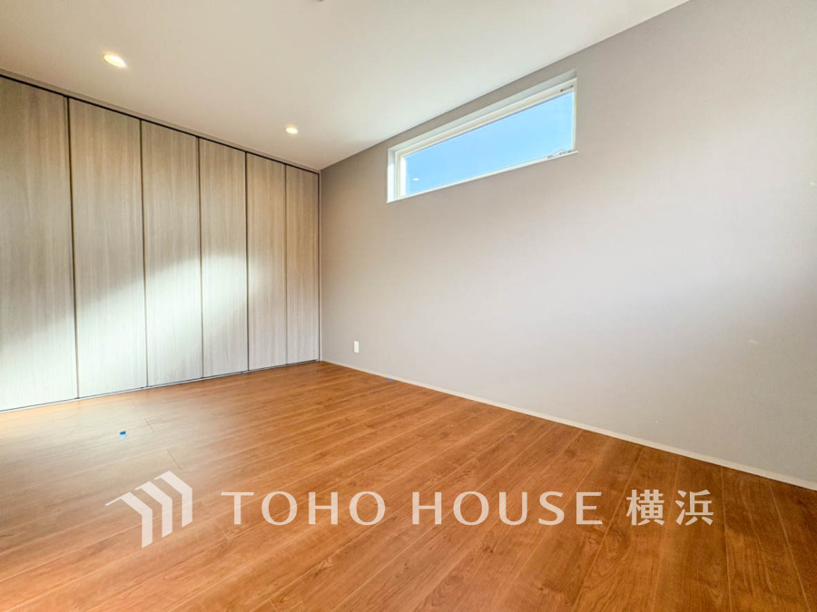 明るい自然光が差し込むシンプルな洋室。壁一面の大容量クローゼットで収納も充実しています。