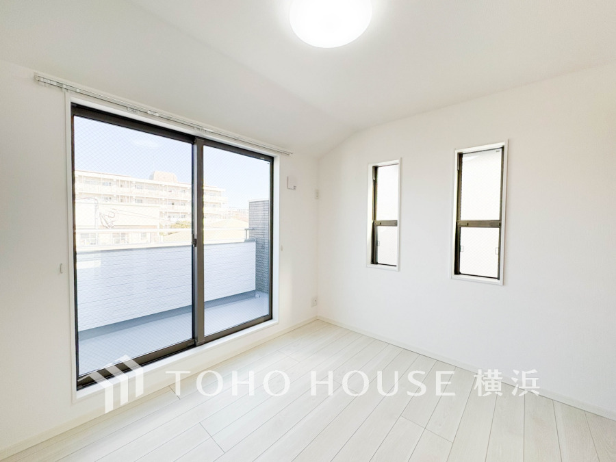 明るい自然光が差し込むシンプルで清潔感あふれる洋室。バルコニーに面した大きな窓が開放感を演出します。