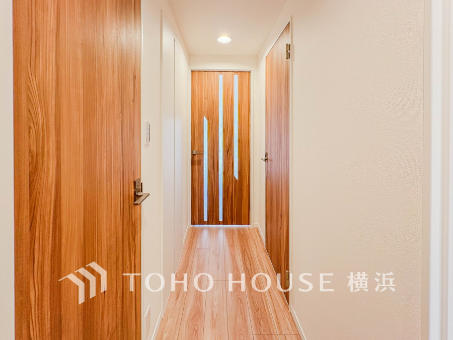 温かみのある木目調のドアと明るいフローリングが調和した、清潔感あふれる廊下スペースです。