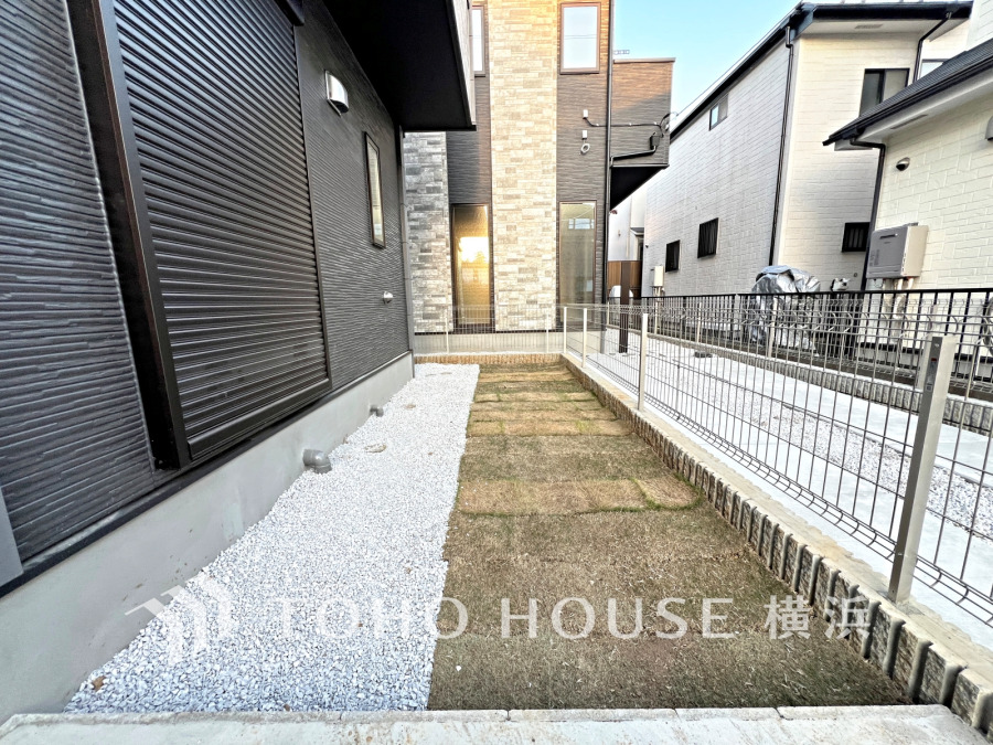 手入れがしやすい砂利と芝生の庭スペース。シンプルで使いやすく、日当たり良好な外部空間です。