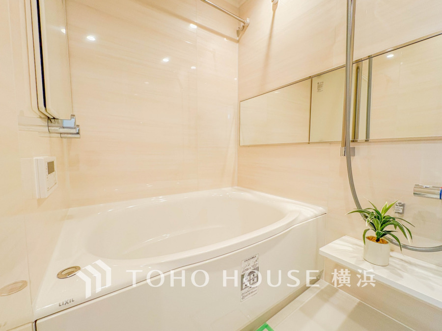 清潔感あふれる白を基調としたバスルーム。広めの浴槽と大きな鏡でゆったりくつろげる空間です。