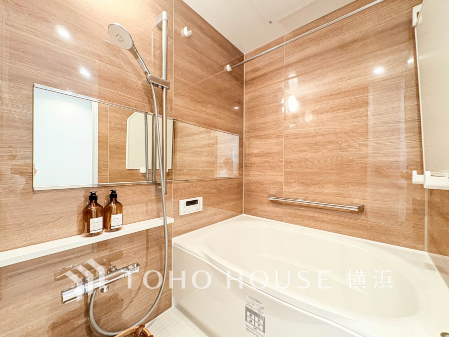 木目調の壁が温かみを演出する清潔感あふれるバスルーム。ゆったり浸かれる浴槽と使いやすいシャワー付きです。