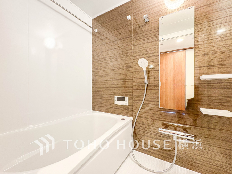 木目調パネルが温かみを演出する清潔感あふれるバスルーム。