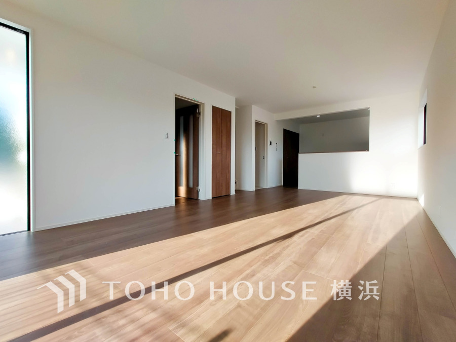 陽光が差し込む広々としたリビングは、シンプルで温かみのある木目床が魅力の快適空間です。