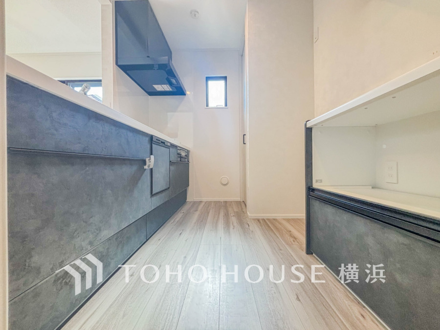 収納棚を背面に設置した統一感のあるキッチンスペースは美しく、機能性も良好です。
