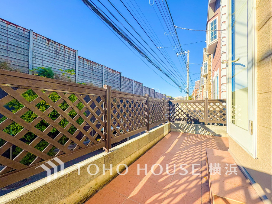 陽当たり良好な広々テラス。ウッドフェンスがプライバシーを守り、くつろぎのアウトドア空間を実現します。