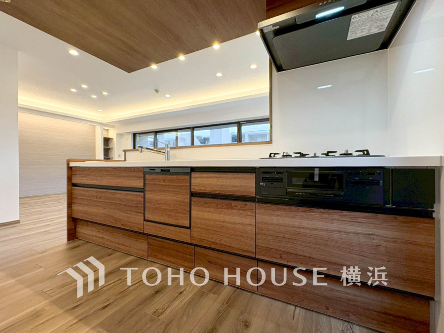 木目調の温かみあるキッチンは、開放的なリビングとつながり家族の会話が弾む設計です。収納も充実しています。