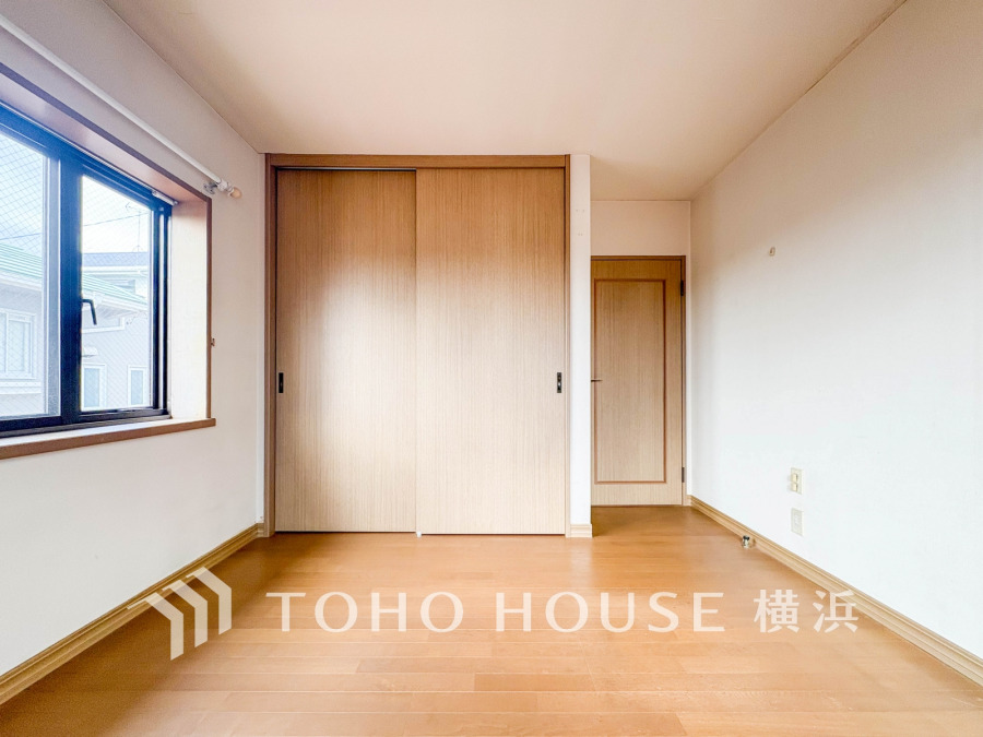 明るい自然光が差し込むシンプルな洋室。大容量の収納スペースで使い勝手も良好です。