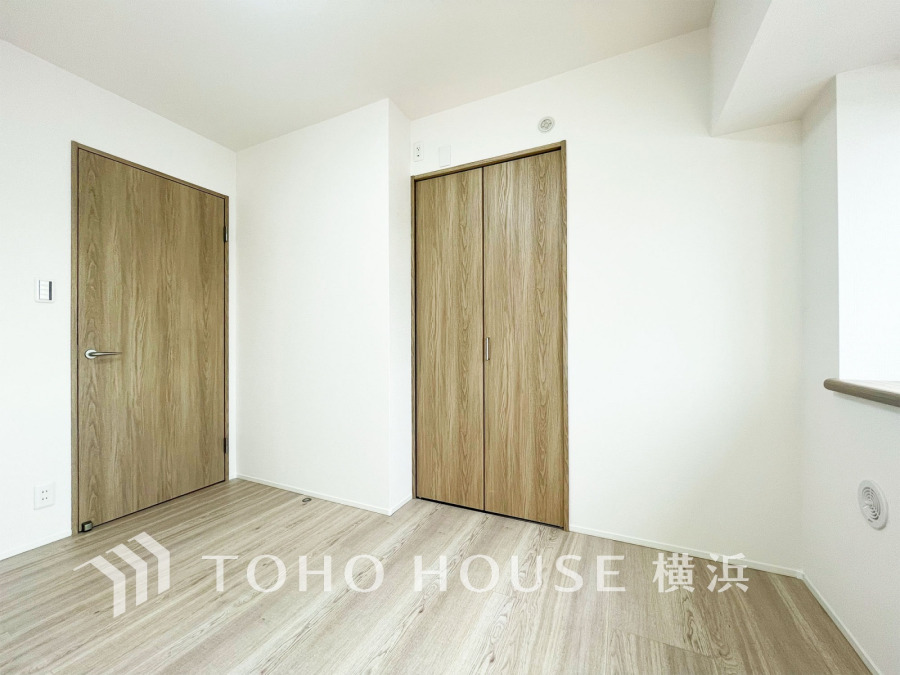 ナチュラルな木目調扉と明るいフローリングが調和した、清潔感あふれるシンプルな洋室空間です。