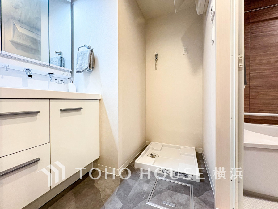 清潔感あふれる洗面スペースと洗濯機置き場を備えた実用的なサニタリー空間です。