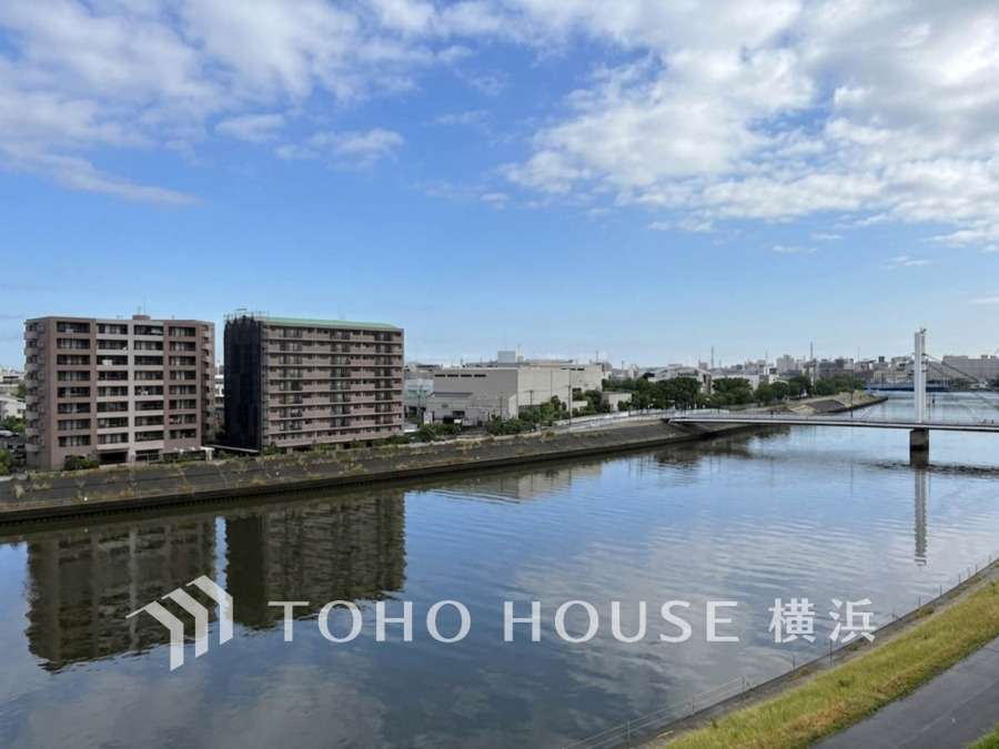 川沿いの開放的な眺望が魅力です。穏やかな水面と青空を見渡すのびやかな景色です。