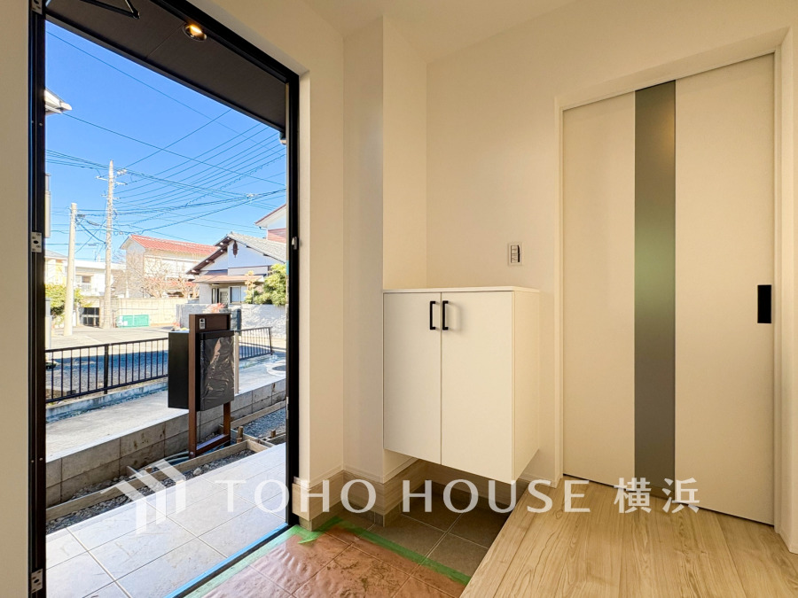 明るい光が差し込む、洗練されたデザインの玄関。浮かせたシューズボックスは、家族の靴をすっきり収納し、いつも清潔な空間を保ちます。