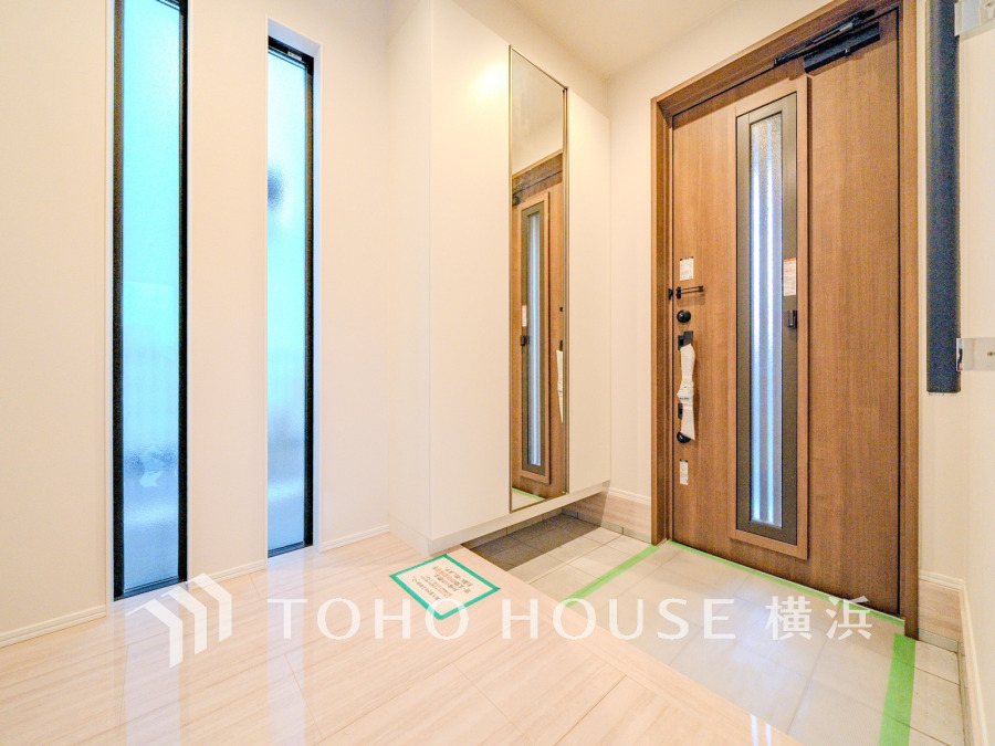 ゆとりと収納を確保した玄関スペース。窓から柔らかな光が差し込む上質な空間です。
