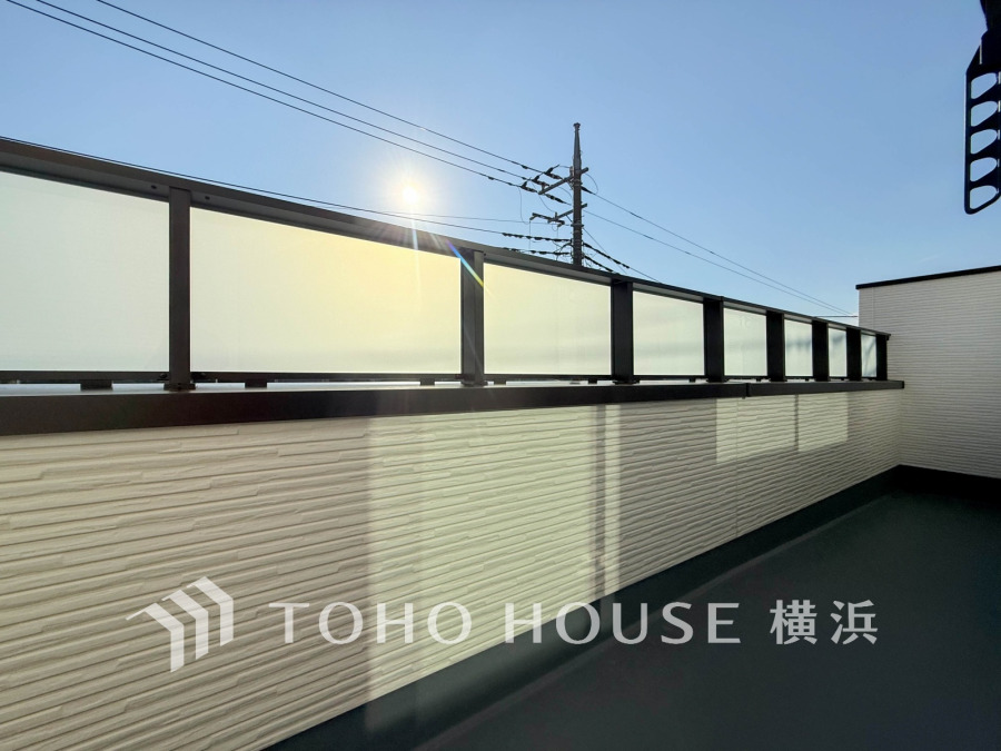 陽射しが心地よく差し込む、プライバシーに配慮したガラスフェンスの広々としたバルコニーです。