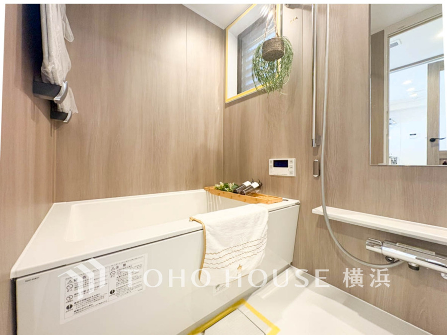 木目調の壁が温かみを演出する清潔感あふれるバスルーム。窓からの自然光で明るく快適な空間です。