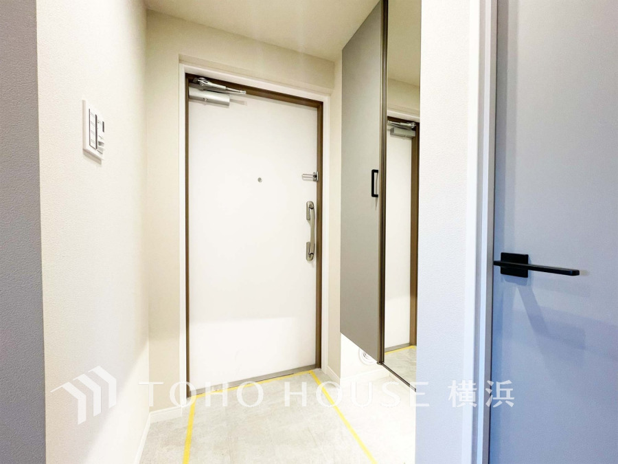 清潔感のある玄関スペース。大型の鏡付き収納で身だしなみチェックも快適に行えます。