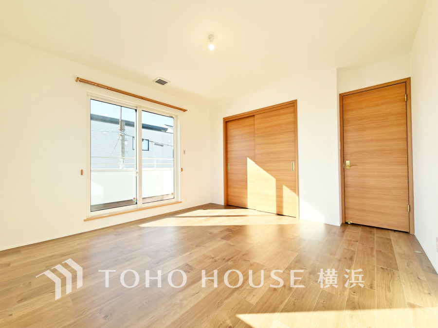 陽光あふれる明るい室内。木目調の床と建具が温かみを演出し、収納も充実した快適な居住空間です。