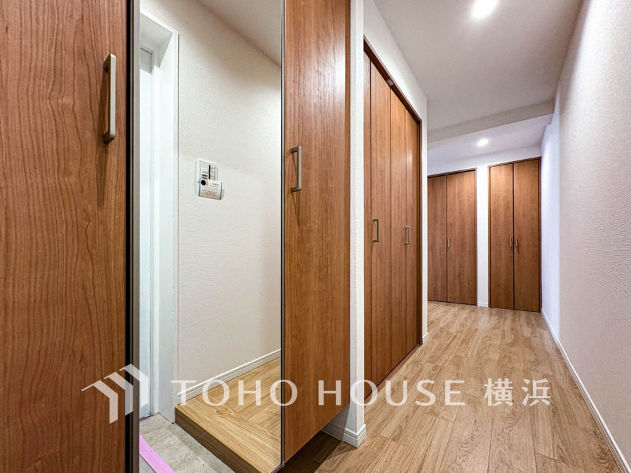 木目調の扉とフローリングが温かみを演出する、収納充実の玄関・廊下スペース。