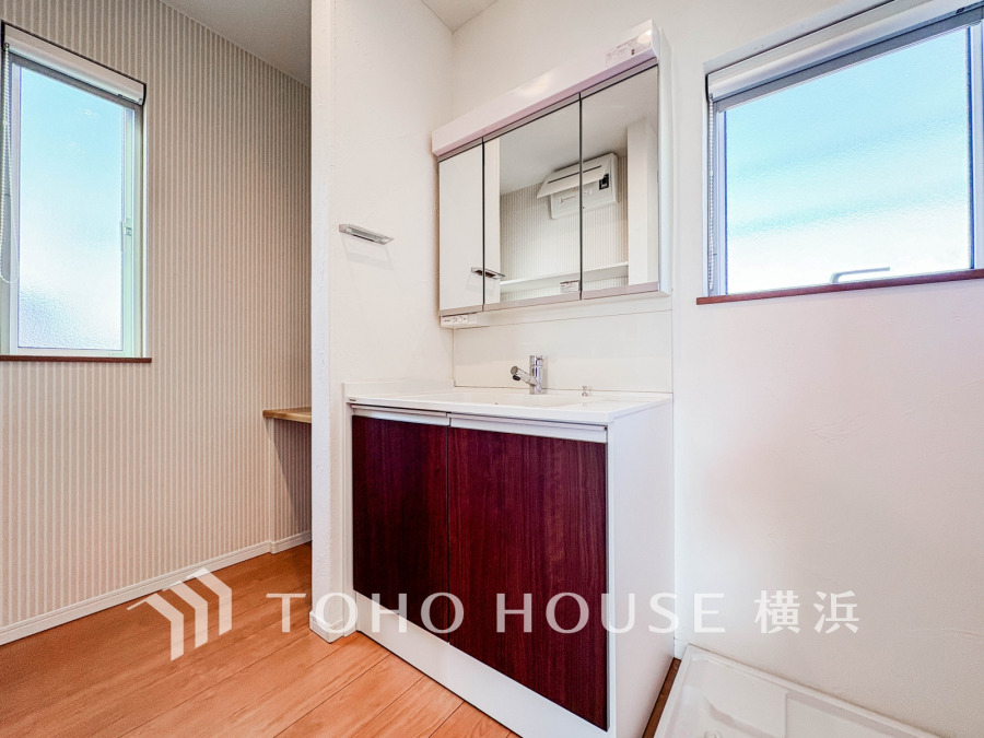 自然光が差し込む明るい洗面スペース。収納力のある三面鏡と清潔感あるデザインで使い勝手も抜群です。