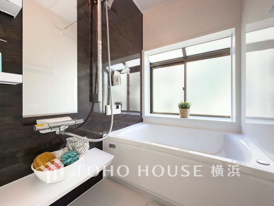 大きな窓から自然光が差し込む、清潔感あふれるモダンなバスルームです。ゆったり寛げる浴槽付き。