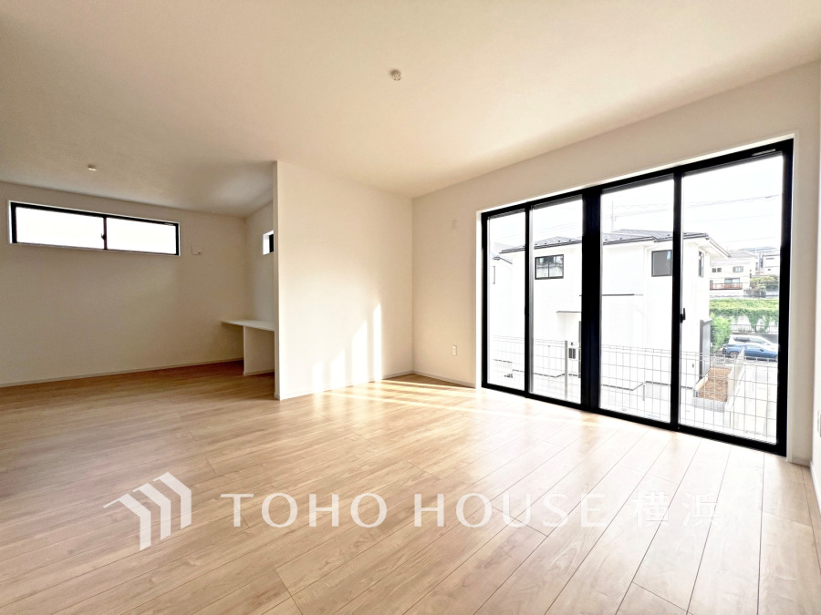 大きな窓から自然光が差し込む、明るく開放的なリビング空間。シンプルで使いやすい設計です。