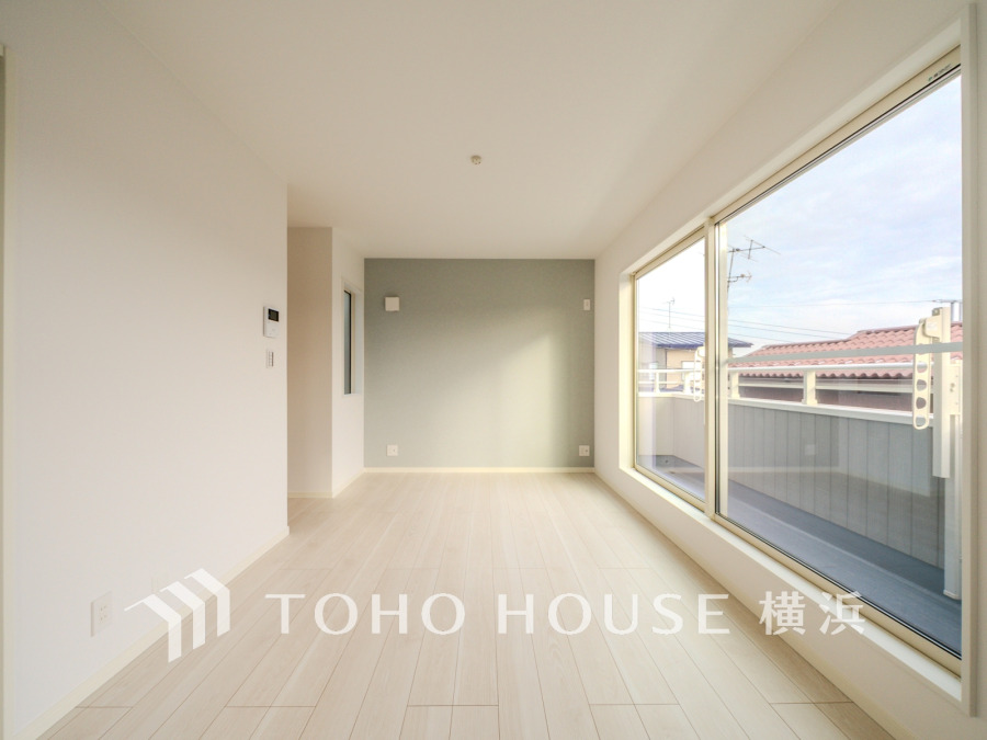 南向きの大きな窓から光が差し込む明るいリビング。シンプルで開放的な空間設計です。