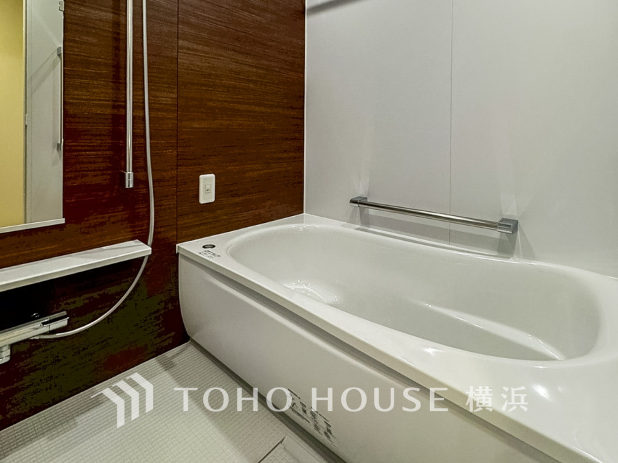 木目調の壁が温かみを演出する清潔感ある浴室。ゆったりくつろげるバスタブで一日の疲れを癒せます。