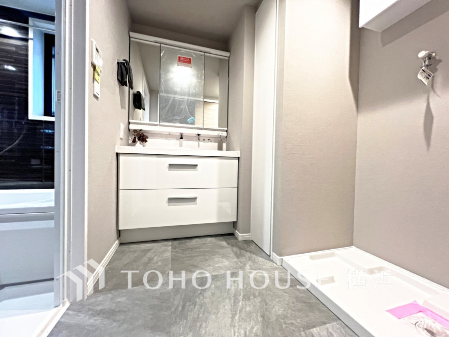 清潔感あふれる洗面室。収納豊富な洗面台と洗濯機置場が効率的に配置された使いやすい空間です。