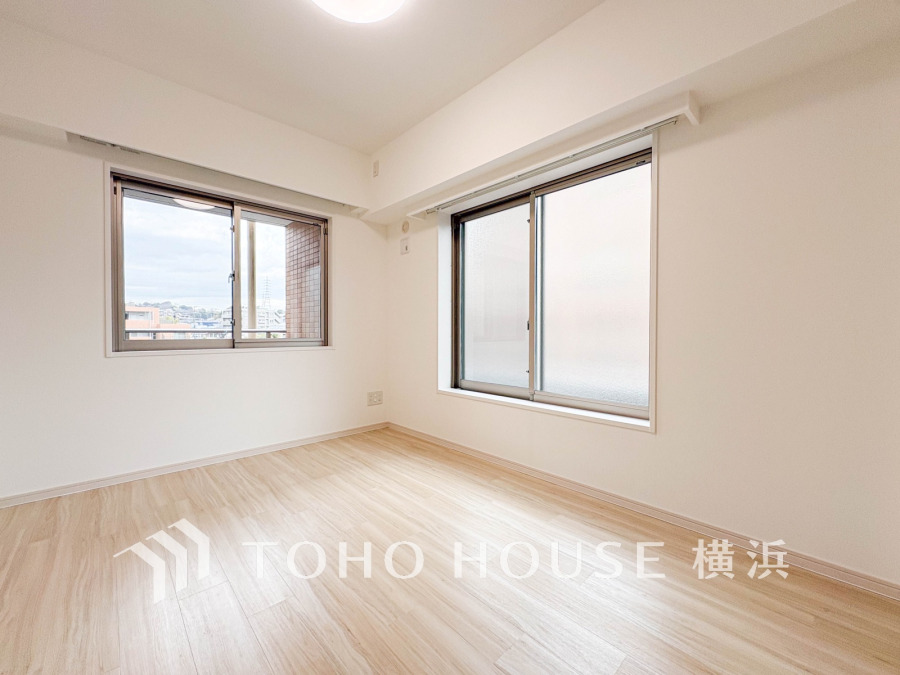 二面採光で明るく風通しの良い洋室。ナチュラルなフローリングが温かみを演出し、快適な居住空間を実現しています。