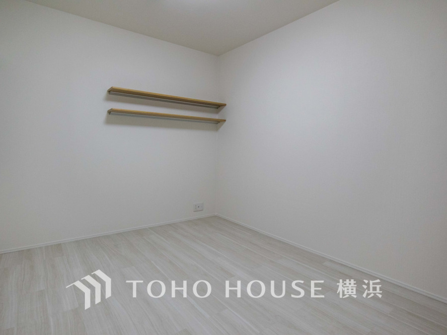 シンプルで清潔感のある白基調の洋室。棚付きで収納やディスプレイにも便利な空間です。