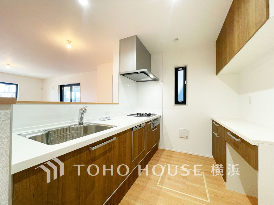 収納棚を背面に設置した統一感のあるキッチンスペースは美しく、機能性も良好です。
