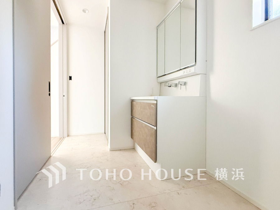 白を基調とした明るい洗面所。収納力のある引き出しと大きな鏡で使い勝手も抜群です。