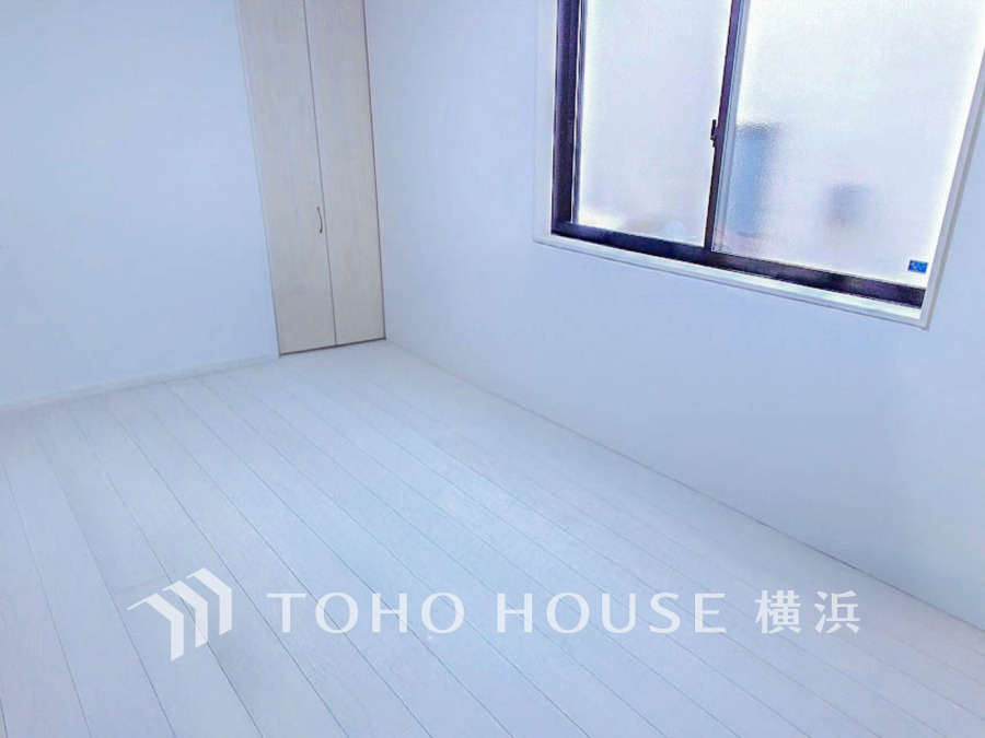 清潔感あふれる白を基調とした洋室。大きな窓から自然光が入り、収納も完備したシンプルな空間です。