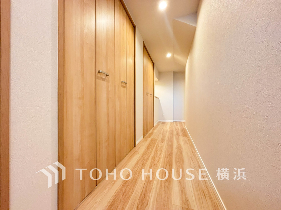木目調の床と扉が温かみを演出する収納豊富な廊下空間です。