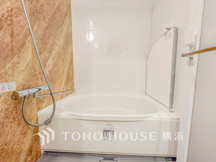 清潔感あふれるシンプルな浴室は、落ち着いた木目調の壁がアクセントとなりリラックス空間を演出します。