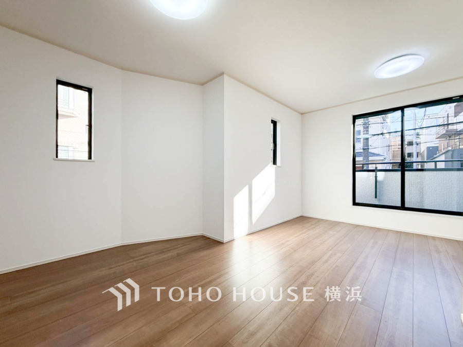 陽光が差し込む広々としたリビング。大きな窓からの眺望とナチュラルな木目床が心地よい空間を演出します。