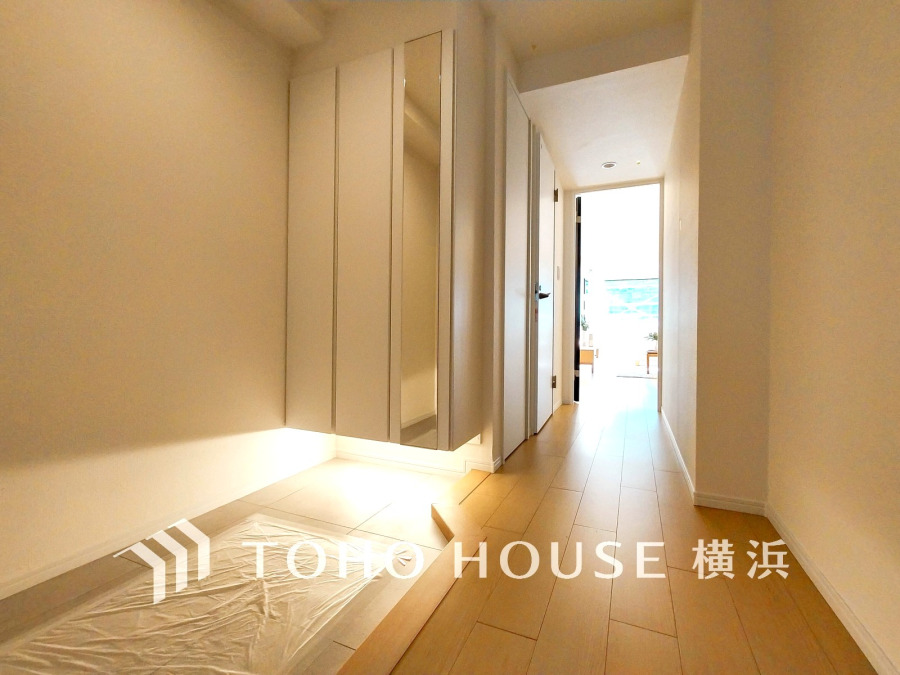 ゆとりと収納を確保した玄関スペース。間接照明が演出する上質な空間です。