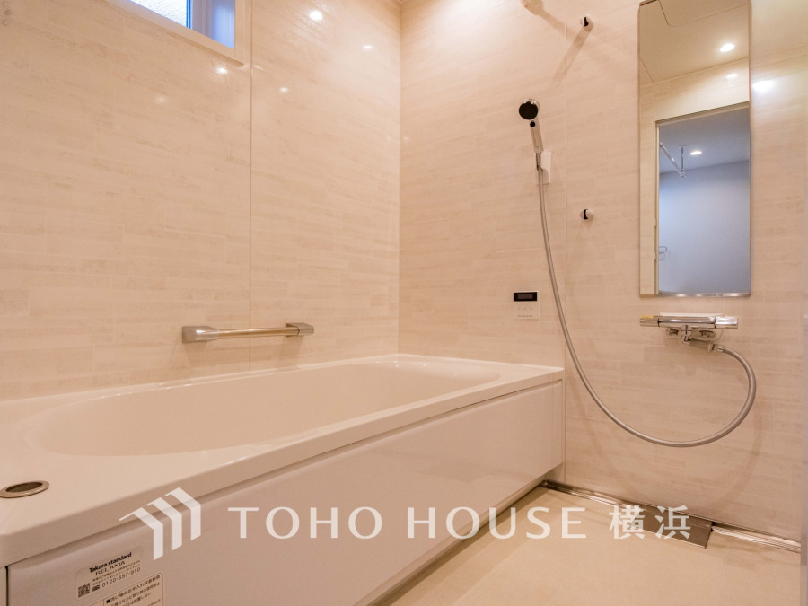 清潔感あふれる白を基調としたバスルーム。広々とした浴槽と使いやすいシャワー設備が魅力です。